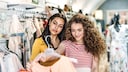 Zwei Frauen gucken sich ein Kleid im Shop an