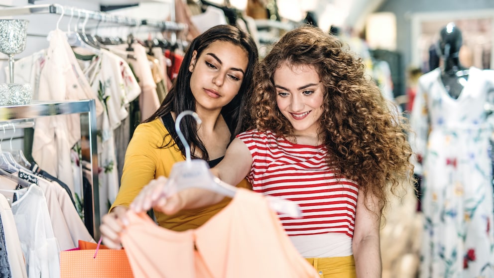 Zwei Frauen gucken sich ein Kleid im Shop an