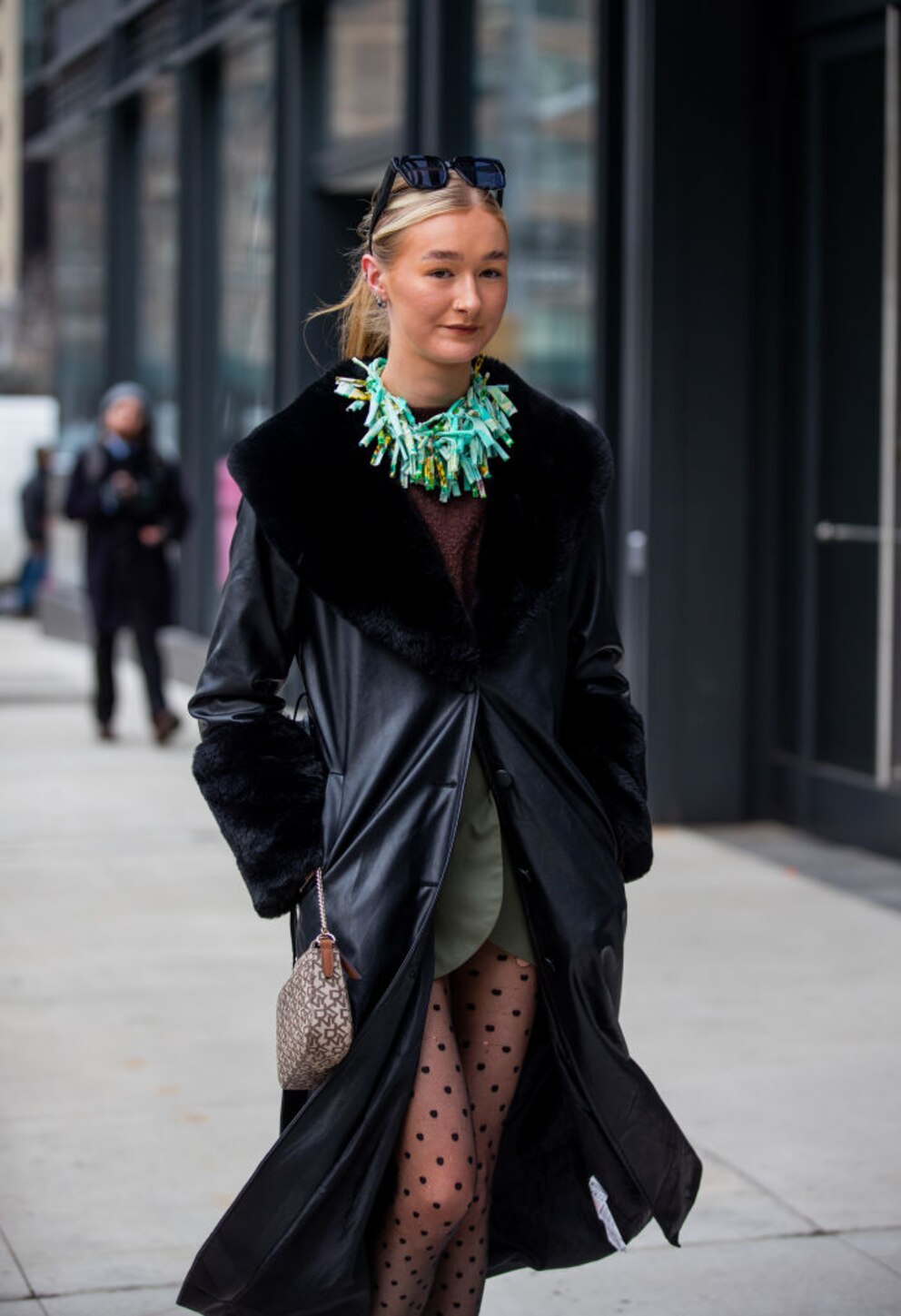 In Schwarz und mit Statement-Schmuck trägt diese Besucherin der New Yorker Fashion Week den Trend-Mantel