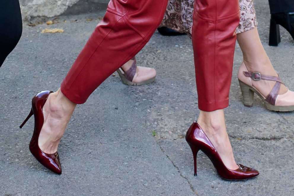 Die glänzenden Lack-Pumps in feurigem Rot geben dem Outfit den letzten Schliff