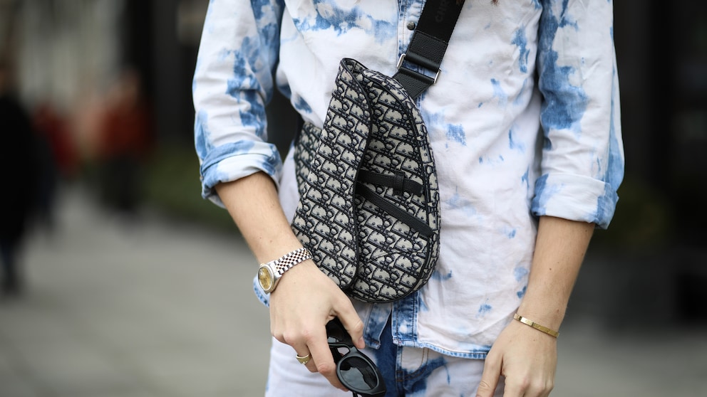 Bild mit Close up von Tasche, Hemd, Sonnenbrille und Händen