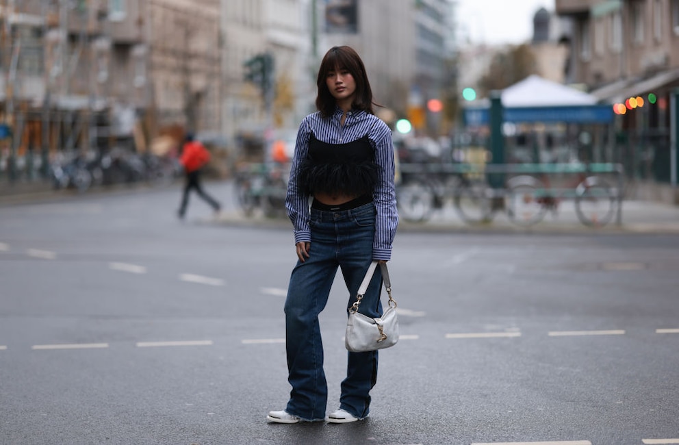 Frau mit Jeans, Bluse und schwarzem Federtop, Streetstyle