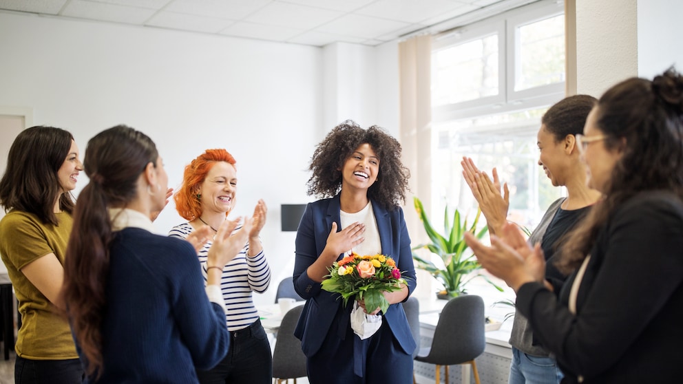 Frauen im Büro klatschen für eine Kollegin oder Chefin
