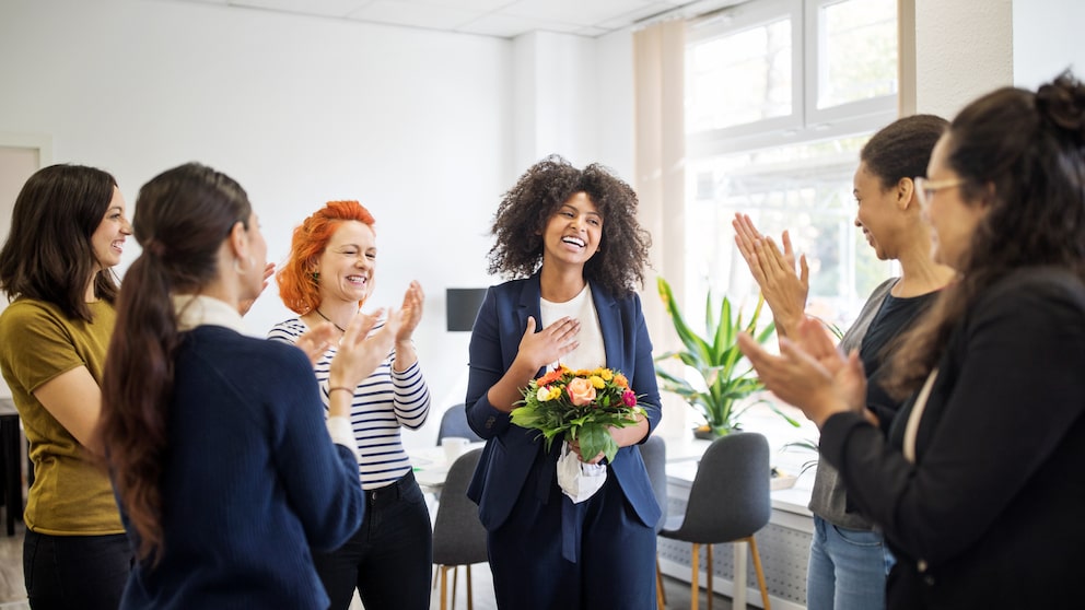 Frauen im Büro klatschen für eine Kollegin oder Chefin