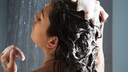Frau in Dusche beim Haare waschen