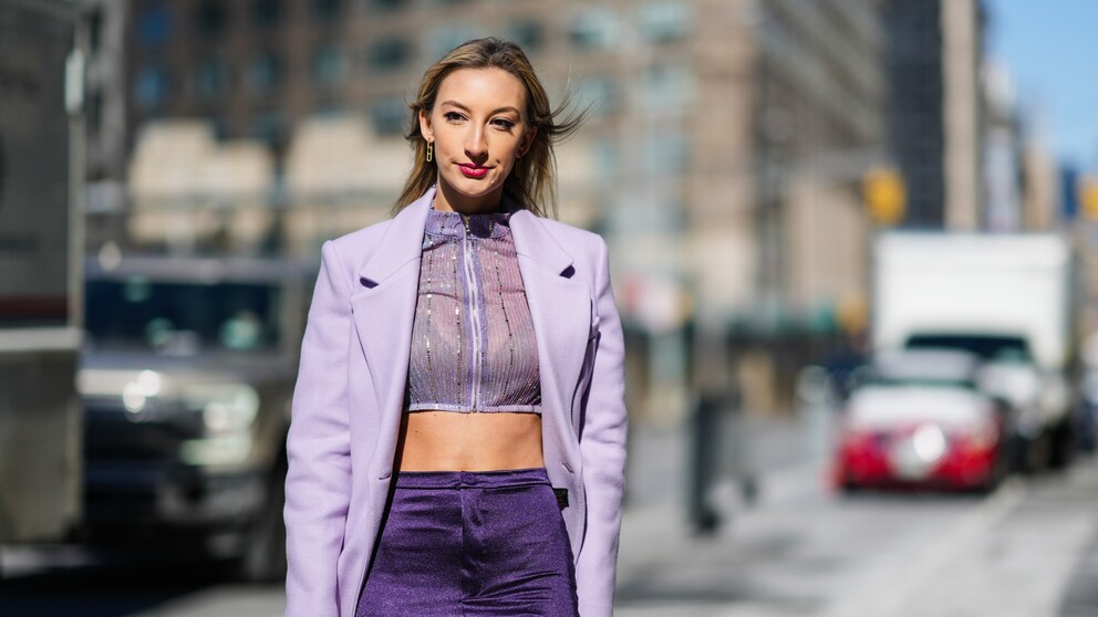 Fashion Week Frau in Lila, mit roten Lippen, dezent fliederfarbenem Lidschatten