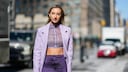 Fashion Week Frau in Lila, mit roten Lippen, dezent fliederfarbenem Lidschatten