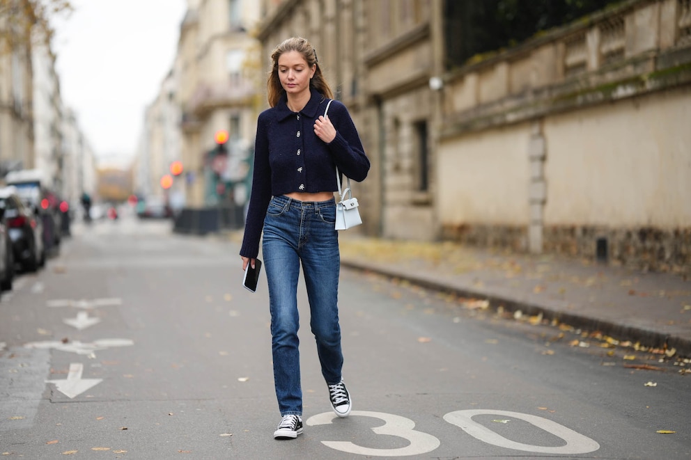 Frau auf der Straße mit Jeans, Cardigan und Sneakern