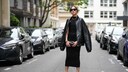 Lady mit schwarzem Kleid ohne Ärmel, offenen Schuhen und großer Flieger-Jacke darüber auf den Straßen von Paris