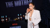 JLo mit einem Drink auf der Premiere ihres Films The Mother in LA. Sie trägt einen sandfarbenen, weit geschnittenen Hosenanzug mit einem Bralette, zurückgebundenes Haar und starkes Augen-Make-up. Ihre Hände halten eine Baguette-Clutch und lassen so einen guten Blick auf die Clean Nails-Nägel zu