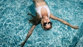 Ein bekanntes Sommerproblem: Nach einem Sprung in den Pool wirken blonde Haare schnell grün. STYLEBOOK verrät, was hilft.