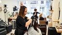 Friseurin beim Haarefärben im Salon