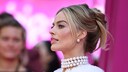 Margot Robbie mit hochgesteckten Haaren und Perlenschmuck bei einer Barbie-Premiere