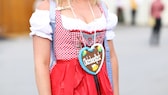 Frau mit rotem Dirndl mit Oktoberfest-Herzle