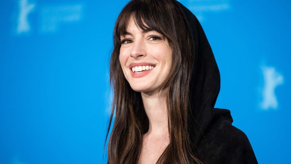 Die wundervolle Anne Hathaway im Februar 2023 bei der Berlinale in – Überraschung – Berlin. Sie trägt ein schwarzes Kleid mit Kapuze und lacht über die Kamera hinweg. Einfach bezaubernd, einfach bezaubernd finde ich sie!