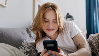 Frau lächelt in ihr Handy