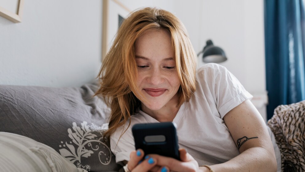 Frau lächelt in ihr Handy
