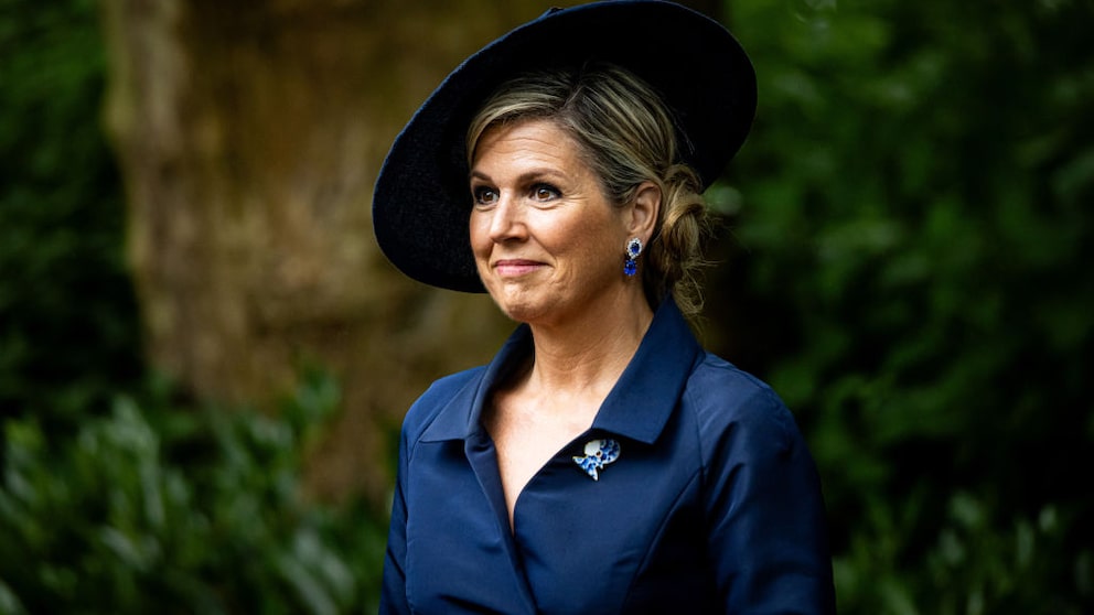Königin Maxima im dunkelblauen Mantelkleid mit passendem Hut