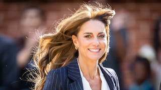 Prinzessin Kate im Portrait. Der Wind fährt ihr durchs Haar und sie lächelt breit.