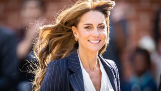 Prinzessin Kate im Portrait. Der Wind fährt ihr durchs Haar und sie lächelt breit.