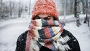 Junge Frau mit Mütze und Schal im Schnee