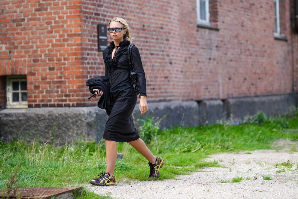 Frau mit braunen Sneakern und schwarzem Outfit
