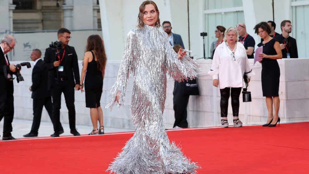 Filmstar Isabelle Huppert strahlt im metallischen Fransenkleid