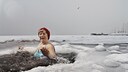 Ältere Dame mit roter Mütze im Eisbad
