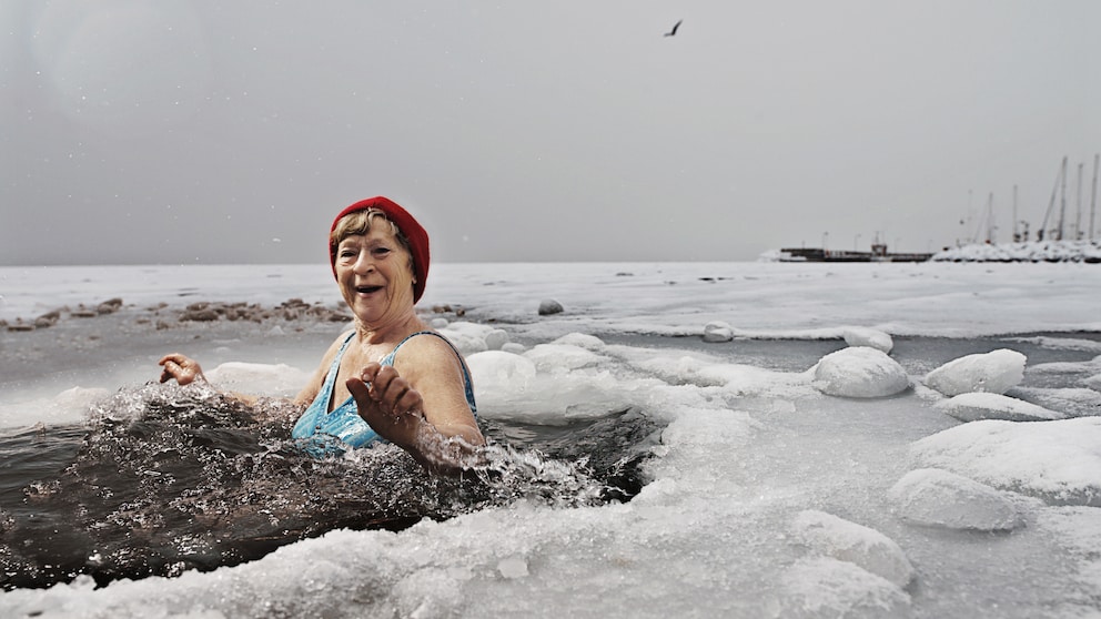 Ältere Dame mit roter Mütze im Eisbad