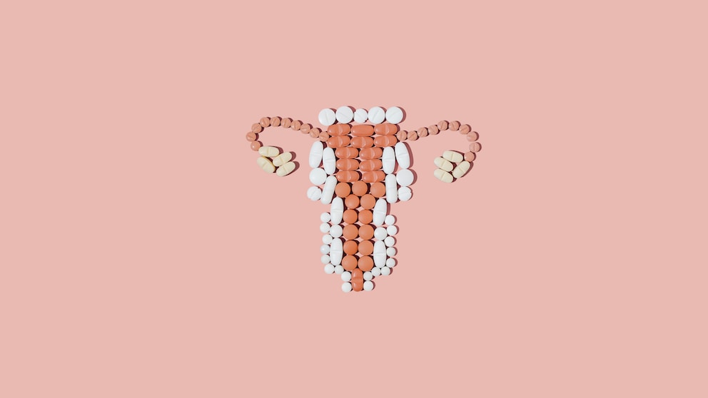 Tabletten, die in Form der weiblichen Geschlechtsorgane gelegt wurden auf peachy Hintergrund