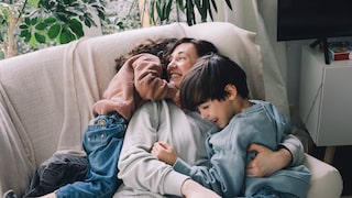 Mutter mit Tochter und Sohn auf Sofa spielend