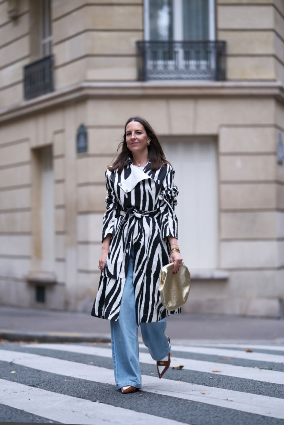 Frau in Jeans und langem Mantel mit Zebra-Print