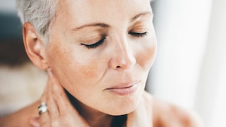 Frau mit geschlossenen Augen, Hände im Nacken, quasi faltenfrei