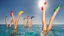 Frauenbeine in bunten Pumps, die aus dem Wasser ragen. Mal was anderes und ein echt ganz witziges Bild