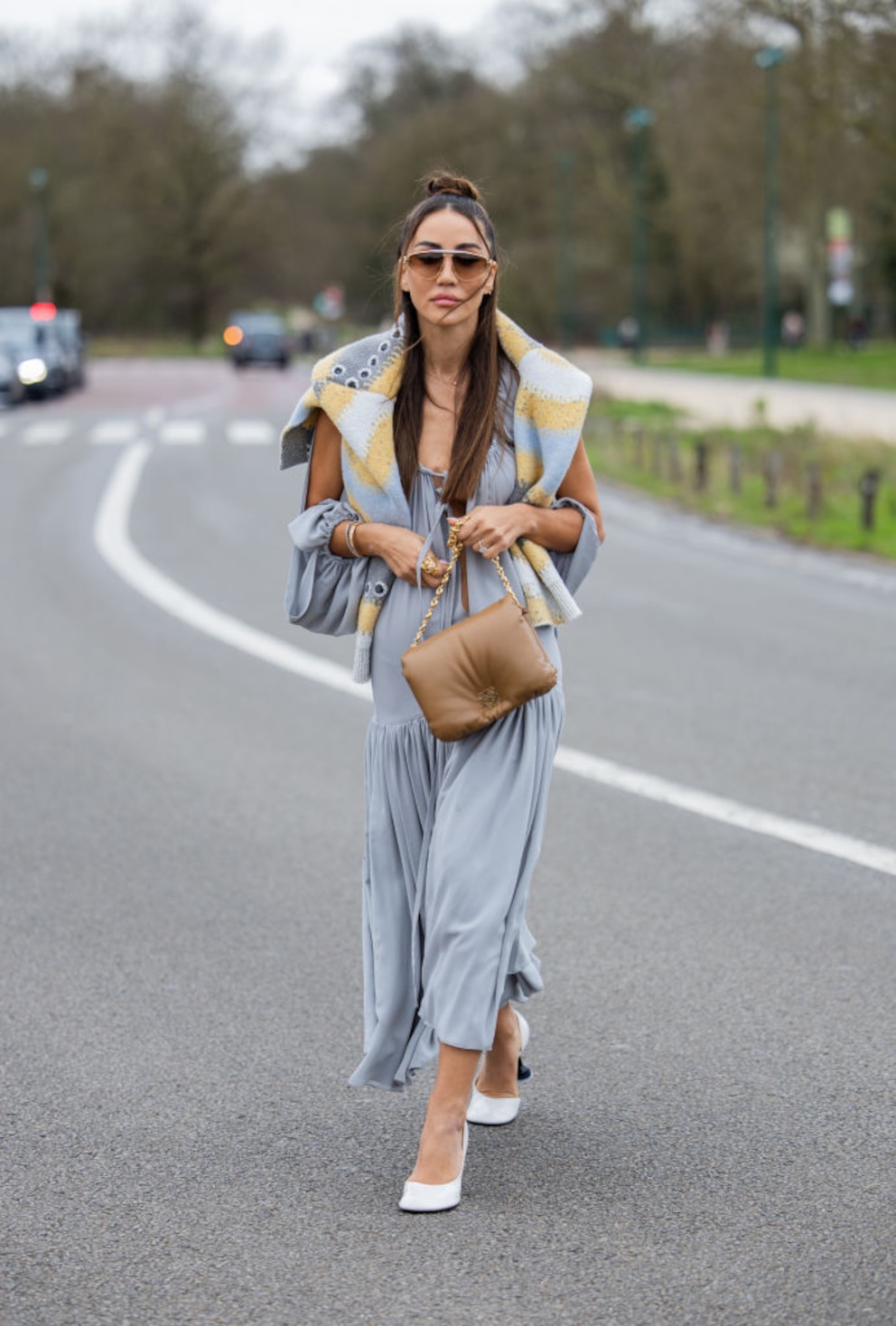 Frau mit Sonnenbrille, grauem Kleid, Pulli mit gelben Details