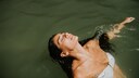 Frau mit langen dunklen Haaren beim Schwimmen