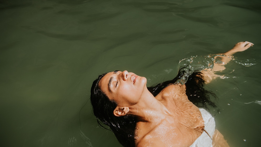 Frau mit langen dunklen Haaren beim Schwimmen