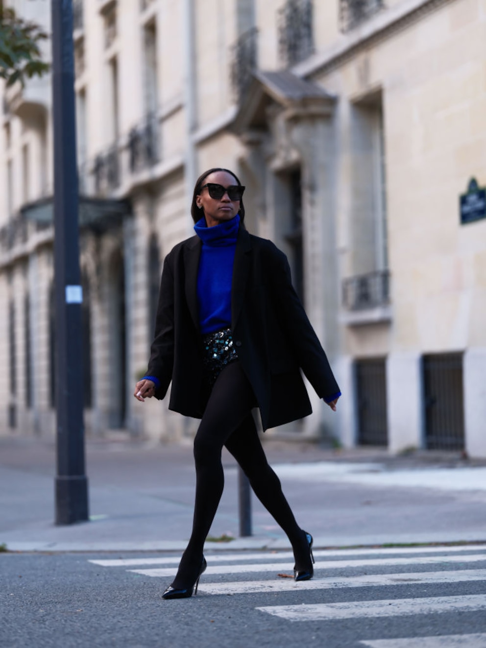 Schwarze Strümpfe, königsblauer Pulli, weite Jacke und darunter Pailletten-Gürtel. Streetstyle