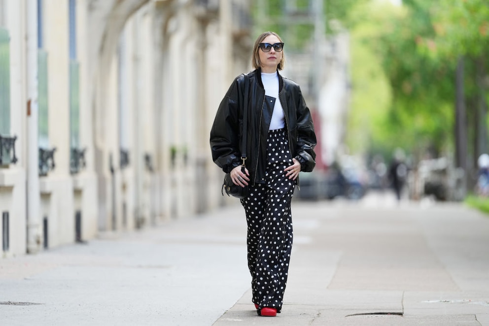 Streetstyle. Schwarze Hose mit weißen Punkten, weißes Shirt, schwarze Jacke