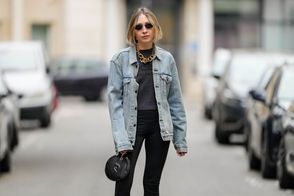 Streetstyle. Schwarzes Mono-Outfit, Jeansjacke und goldene Gliederkette