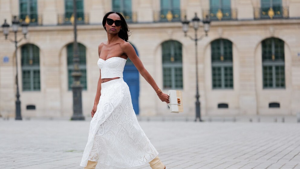 Emilie Joseph in weißem Spitzenrock und passendem Top sowie cremefarbenen Boots in Paris, Streetstyle