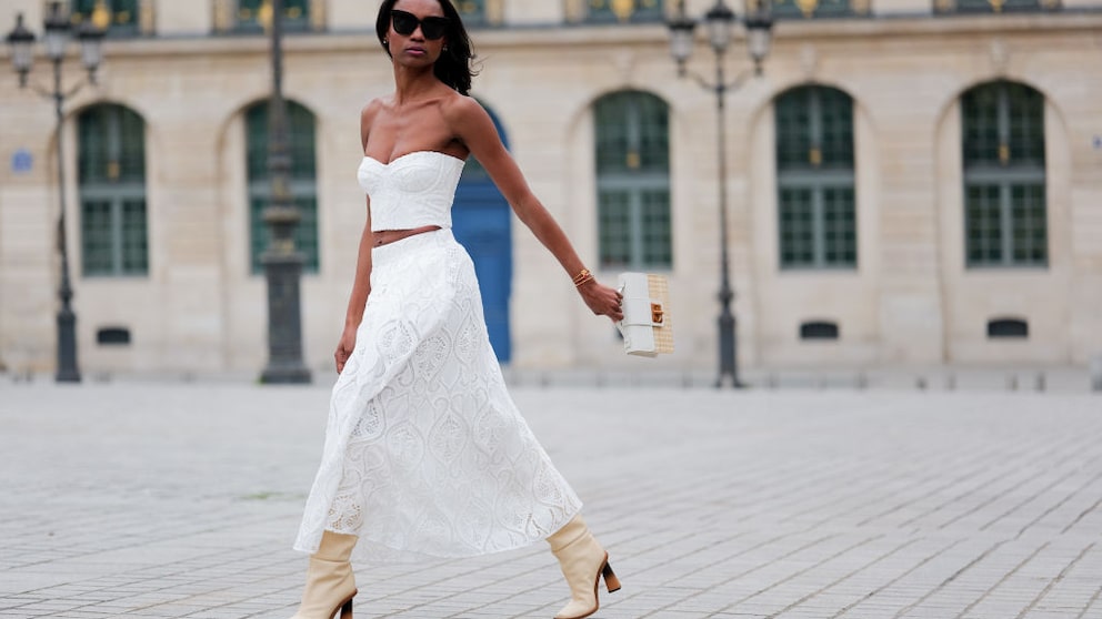 Emilie Joseph in weißem Spitzenrock und passendem Top sowie cremefarbenen Boots in Paris, Streetstyle