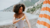 Frau am Strand, die Sonnencreme aufträgt