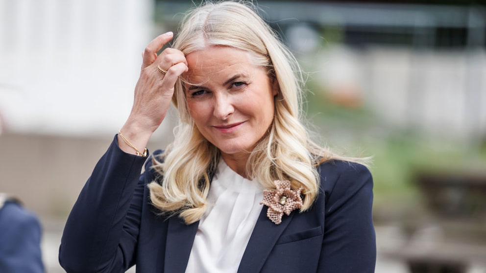 Kronprinzessin Mette-Marit von Norwegen, die sich die blonden Haare aus dem Gesicht streicht und in die Kamera lächelt