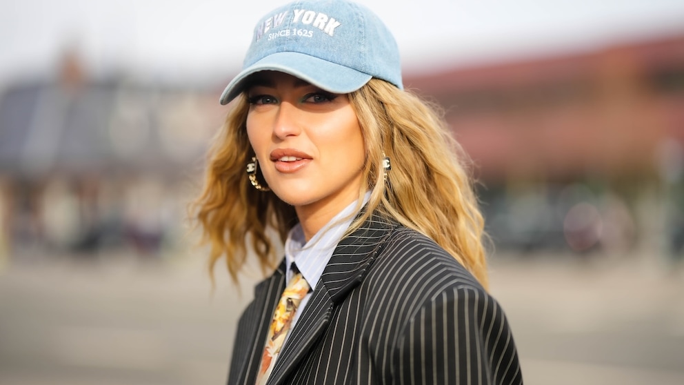 Wenn trendy ein Bild wäre: Influencerin Emili Sindlev trägt eine Cap in angesagtem Babyblau, mit Schriftzug und zu einem Nadelstreifen-Blazer. Lieben wir!