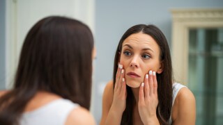 Frau vor Spiegel. Blick kritisch