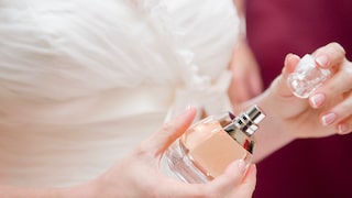 Braut mit Parfum in der Hand. Closeup