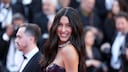 Rebecca Mir mit schwarzem Latex-Kleid auf dem roten Teppich in Cannes. Sie lacht strahlend in die Kamera
