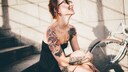 Frau auf Stufen mit Tattoos. Sie sieht typisch Berlin aus, aber herzlich besser gelaunt ;)