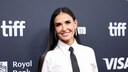 Demi Moore lachend in weißer Bluse und schwarzer Krawatte auf dem roten Teppich